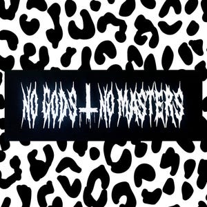 Könnte beinhalten: Schwarzer rechteckiger Aufnäher mit dem Text "NO GODS + NO MASTERS" in weißer, gotischer Schrift. Der Aufnäher zeigt ein weißes Kreuzsymbol. Der Hintergrund ist ein schwarz-weißes Leopardenmuster.