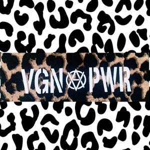 Könnte beinhalten: Ein rechteckiger Aufnäher mit dem weißen Text "VGN PWR" und einem zentralen Symbol, vor einem Leopardenmuster. Der Hintergrund ist ein schwarz-weißes Leopardenmuster.