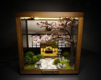 照明付きの木製とガラス製のテラリウムに収められた日本の町家ジオラマ