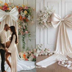 May include: A white backdrop with a large white satin bow and floral arrangements on either side. A couple are standing in front of the backdrop, the woman is pregnant.