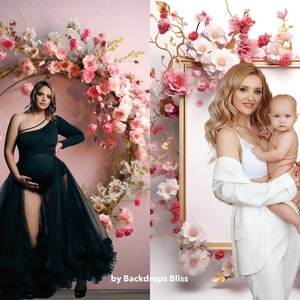 May include: Two women, one pregnant, pose in front of floral backdrops. The pregnant woman wears a black dress with a tulle skirt. The other woman wears a white blazer and holds a baby. Both backdrops feature pink and white flowers.