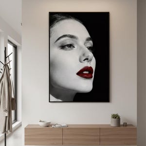 May include: Black and white portrait of a woman with dark red lipstick. The framed artwork hangs above a wooden console table. The room has a modern design with a neutral color palette.