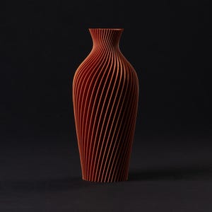 Peut inclure: Un vase de couleur terre cuite avec un design unique. Le vase présente une série de lignes verticales incurvées qui créent un motif tourbillonnant. Il a un col étroit et une base plus large, et il repose sur une surface sombre.