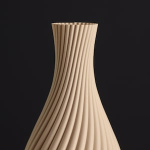 May include: A beige ceramic vase with a unique, swirling, ribbed design. The vase is tall and slender, with a narrow opening at the top.