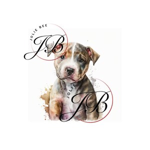 May include: Watercolor illustration of a puppy with a white, brown, and gray coat. The puppy has a sweet expression and is set against a white background with brown paint splatters. The text "Jolie Bee" and "JB" are in the image.