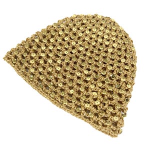 Op de afbeelding: Een goudkleurige muts gemaakt van gehaakt garen met een open weefpatroon. Het gehele oppervlak van de muts is versierd met kleine, ronde, metallic gouden lovertjes die in het breipatroon zijn verwerkt, wat zorgt voor een textuurrijk uiterlijk.