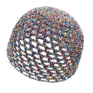 May include: A colorful, open-weave hat with a rounded shape. The hat is made of metallic threads in shades of blue, pink, yellow, and green. The open weave creates a textured appearance. The hat is set against a white background.