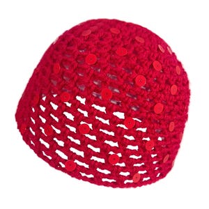 May include: A bright red crocheted beanie hat with red sequins. The hat is made of a loosely woven yarn, allowing glimpses of the background. The sequins are evenly spaced across the surface, adding a touch of sparkle to the handmade accessory.
