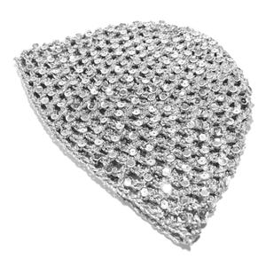 May include: A silver crocheted beanie hat with a dense, open weave. The hat is covered in small, reflective sequins, giving it a shimmering appearance. The hat is shown against a white background.