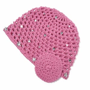 May include: A pink crocheted hat with a star and sequin embellishments. The hat features a circular design on the side and is made of a woven material. The hat is a solid pink color.