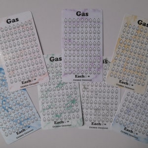 May include: Six sheets of stickers with a petrol pump icon on each sheet. The sheets are in different colours: blue, green, purple, yellow, and white. Each sheet has the text "Gas" and "Each = Debbie Design" printed on it.