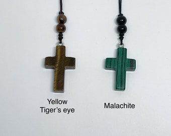 May include: Two necklaces with cross pendants. The cross on the left is made of yellow tiger's eye stone. The cross on the right is made of green malachite stone.