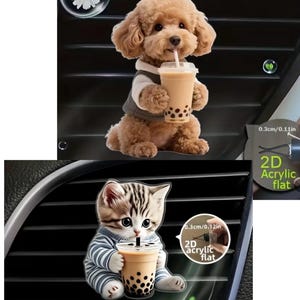 May include: Two 2D acrylic flat car vent decorations. One features a brown poodle wearing a vest, holding a boba drink. The other shows a kitten in a striped shirt, also with a boba drink. Each decoration is 0.3 inches in size.