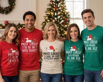 May include: A group of five people wearing Christmas-themed t-shirts. The shirts are red, green, and beige, each with a Santa hat design and text like "Most Likely to be on Santa's Favorite." A Christmas tree is in the background.