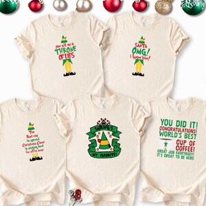 May include: Five cream-colored t-shirts with Christmas-themed graphics and text. The shirts feature elf-themed designs with phrases like "You sit on a throne of lies" and "Santa OMG! I know him!" Festive and fun for the holiday season.
