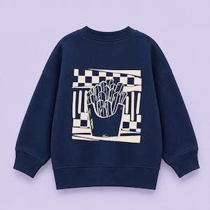 Könnte beinhalten: Ein dunkelblaues Langarm-Sweatshirt mit einem cremefarbenen Grafikdruck auf der Rückseite. Das Design zeigt eine Portion Pommes frites vor einem karierten Hintergrund, dargestellt in einem kräftigen, stilisierten Grafik-Illustrationsstil.