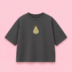 Könnte beinhalten: Ein anthrazitfarbenes Kurzarm-T-Shirt mit einer kleinen, mittig platzierten Grafik einer hellgrünen Birne mit lächelndem Gesicht, geschlossenen Augen und zwei kleinen braunen Blättern oben. Das T-Shirt hat einen Rundhalsausschnitt und eine lockere Passform.