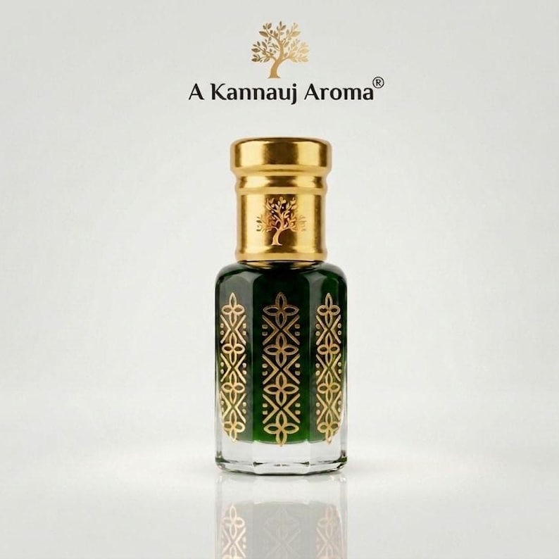 May include: A glass perfume bottle with a dark green body and gold geometric patterns. The bottle features a gold cap with a tree emblem and the text A Kannauj Aroma. The design includes a matching tree logo above the brand name text.