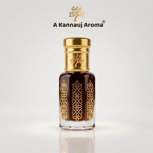 Könnte beinhalten: Eine Glasparfümflasche gefüllt mit dunkler Flüssigkeit, mit einem goldenen Verschluss und goldenen geometrischen Blumenmustern an den Seiten. Der Text A Kannauj Aroma ist über der Flasche mit einem goldenen Baumsymbol abgedruckt.