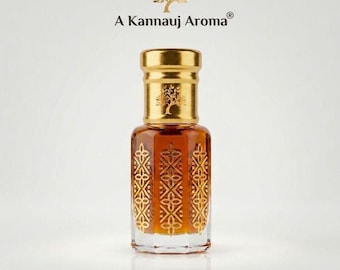 May include: A glass perfume bottle filled with amber liquid, featuring a gold cap with a tree emblem and gold geometric patterns on the sides. Above the bottle, the text A Kannauj Aroma is displayed with a gold tree icon centered above it.