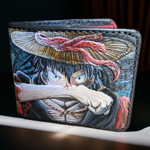 Cartera/billetera de Luffy y kaido. Dibujada, repujada, pintada y cosida a mano.