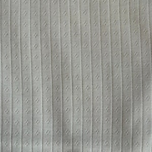 May include: White fabric with a textured pattern of vertical lines and small dots.