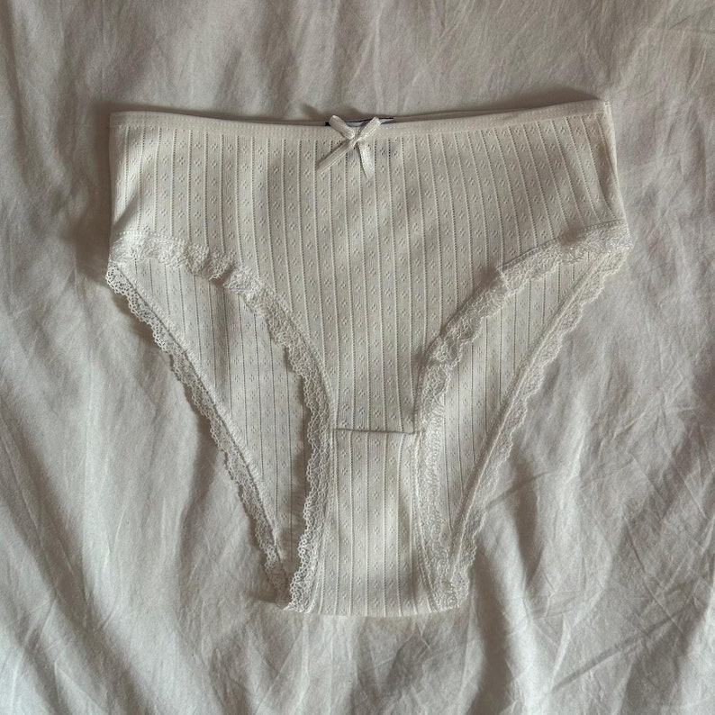 May include: White lace trimmed underwear with a ribbed texture.