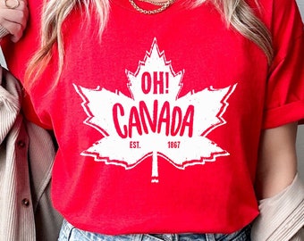 May include: Red t-shirt with a white maple leaf graphic and the text "Oh! Canada Est. 1967".