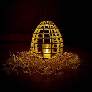 Op de afbeelding: Een houten, eivormige lantaarn met een geometrisch ontwerp. De lantaarn is verlicht met een kaars erin, waardoor een warme gloed wordt gecreëerd. De lantaarn staat op een bed van gescheurd papier.