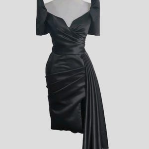 May include: A black satin dress with a sweetheart neckline and puff sleeves. The dress has a fitted bodice and a flowing skirt with a side slit.
