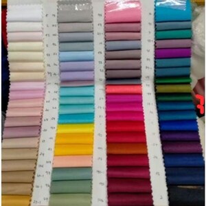 May include: A colour chart with fabric swatches in various colours, including white, light blue, pink, red, green, and blue. The swatches are arranged in rows and columns, with numbers next to each swatch.