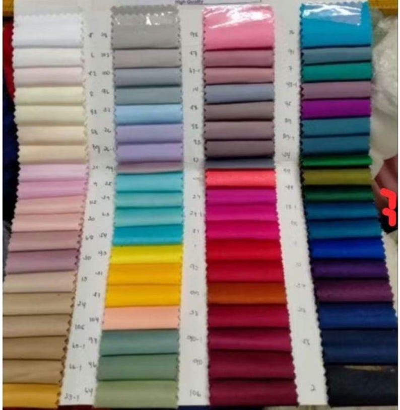 May include: A colour chart with fabric swatches in various colours, including white, light blue, pink, red, green, and blue. The swatches are arranged in rows and columns, with numbers next to each swatch.