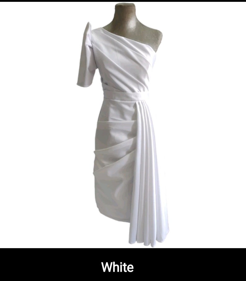 May include: White one-shoulder dress with a draped skirt and a fitted bodice.