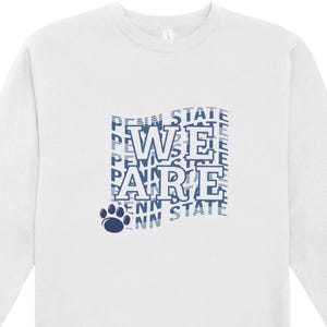 May include: White sweatshirt with the text "WE ARE" in blue, with the words "PENN STATE" repeated in the background. A blue paw print is at the bottom. The sweatshirt is a crew neck.