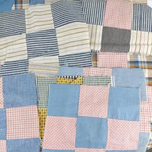 May include: A patchwork quilt composed of various fabric squares featuring diverse patterns including blue and white stripes, pink and white gingham, solid light blue, yellow floral prints, and small-scale geometric designs stitched together.
