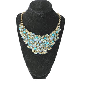 Collar babero vintage de pasarela con pedrería en tonos azules y un toque de glamour atrevido.
