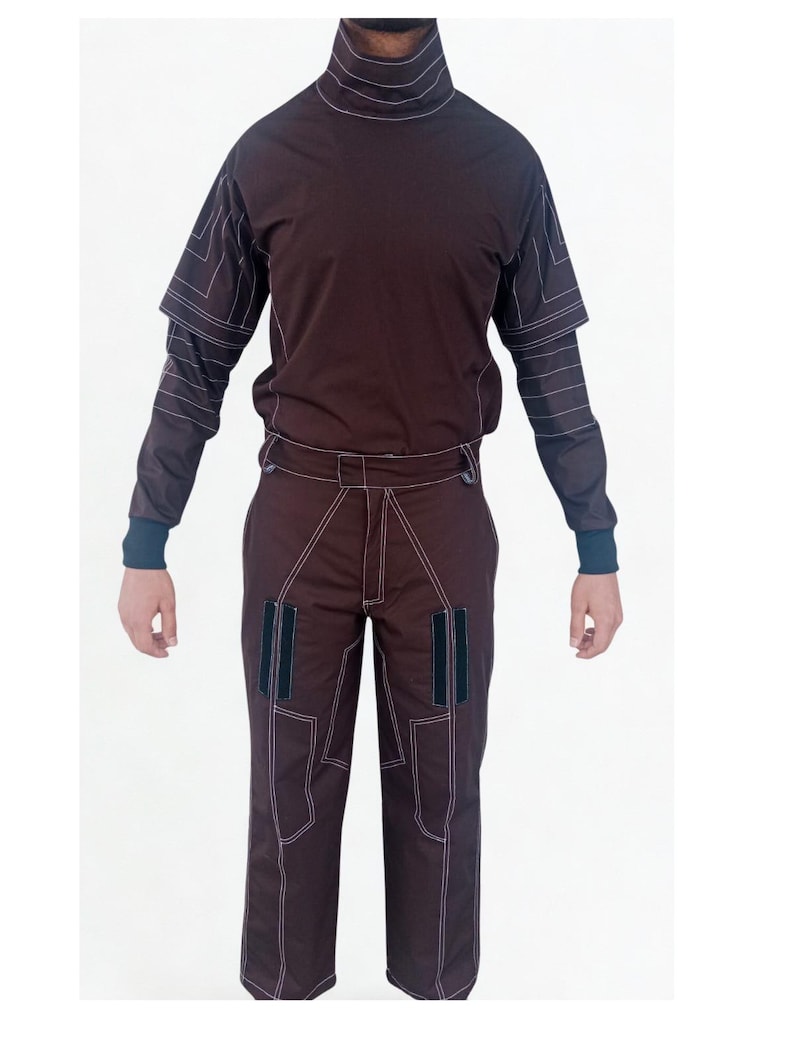 May include: A brown two-piece outfit featuring a high-neck top and matching pants. The top has short sleeves over long sleeves, and the pants have pockets. White stitching outlines the seams and details of the outfit. The outfit is displayed against a white background.