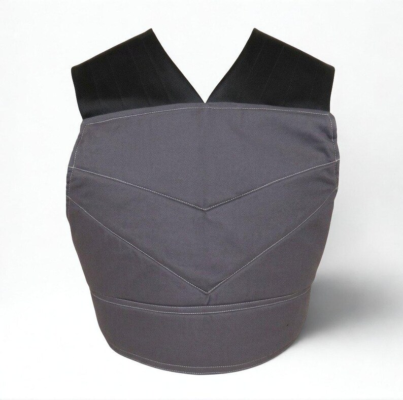 Puede incluir: Un chaleco gris con correas negras para los hombros. El chaleco tiene un dise&ntilde;o de chevr&oacute;n con costuras blancas. El chaleco est&aacute; hecho de una tela duradera y est&aacute; dise&ntilde;ado para usarse sobre la ropa.