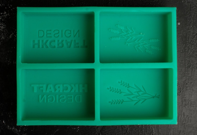 May include: Green silicone mold with four rectangular sections. Two sections have the text "DESIGN HKCRAFT" embossed in the mold. The other two sections have a floral design embossed in the mold.