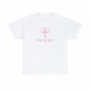 May include: White t-shirt with a pink cross and the text "Child of God" printed on the front.