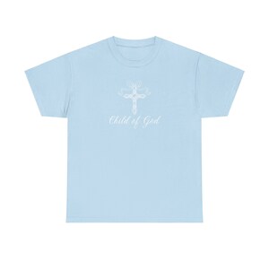 May include: Light blue t-shirt with a white cross design and the text "Child of God" printed on the front.
