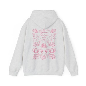 May include: A gray hooded sweatshirt with a pink graphic print on the back. The graphic features a key, birds, teacups, and the text "Protect your heart!"