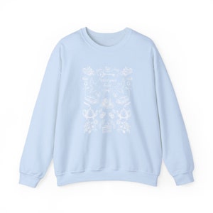 May include: A light blue sweatshirt with a white graphic design featuring a key, a teacup, and the text "Protect your heart".