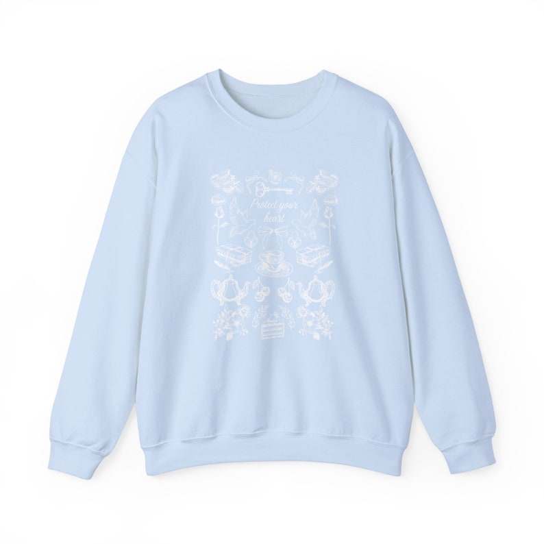 May include: A light blue sweatshirt with a white graphic design featuring a key, a teacup, and the text "Protect your heart".