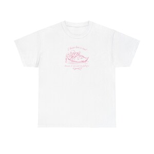 May include: White t-shirt with a pink graphic of two swans and the text "I know love is real because I trust and I'm full of it."