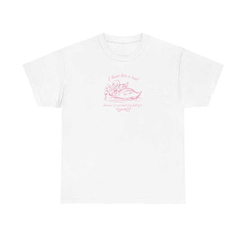 May include: White t-shirt with a pink graphic of two swans and the text "I know love is real because I trust and I'm full of it."