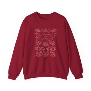 May include: Burgundy red sweatshirt with a white graphic design featuring a key, birds, teacups, and the text "Protect your heart".