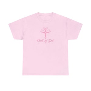 May include: Pink t-shirt with a pink cross and the text "Child of God" printed on the front.
