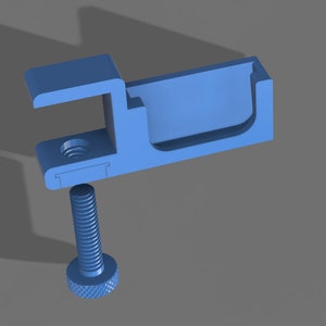 Könnte beinhalten: Eine hellblaue, 3D-gedruckte Klemme mit einer Schraube. Die Klemme hat eine C-förmige Öffnung und einen rechteckigen Kanal. Die Schraube hat einen gerändelten Kopf. Das Objekt befindet sich vor einem grauen Hintergrund.
