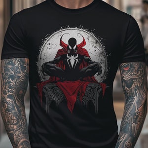 Puede incluir: Una camiseta negra con un estampado gráfico de un superhéroe con una capa roja y un traje negro sentado en un trono. El superhéroe está rodeado de un círculo blanco con un contorno negro.